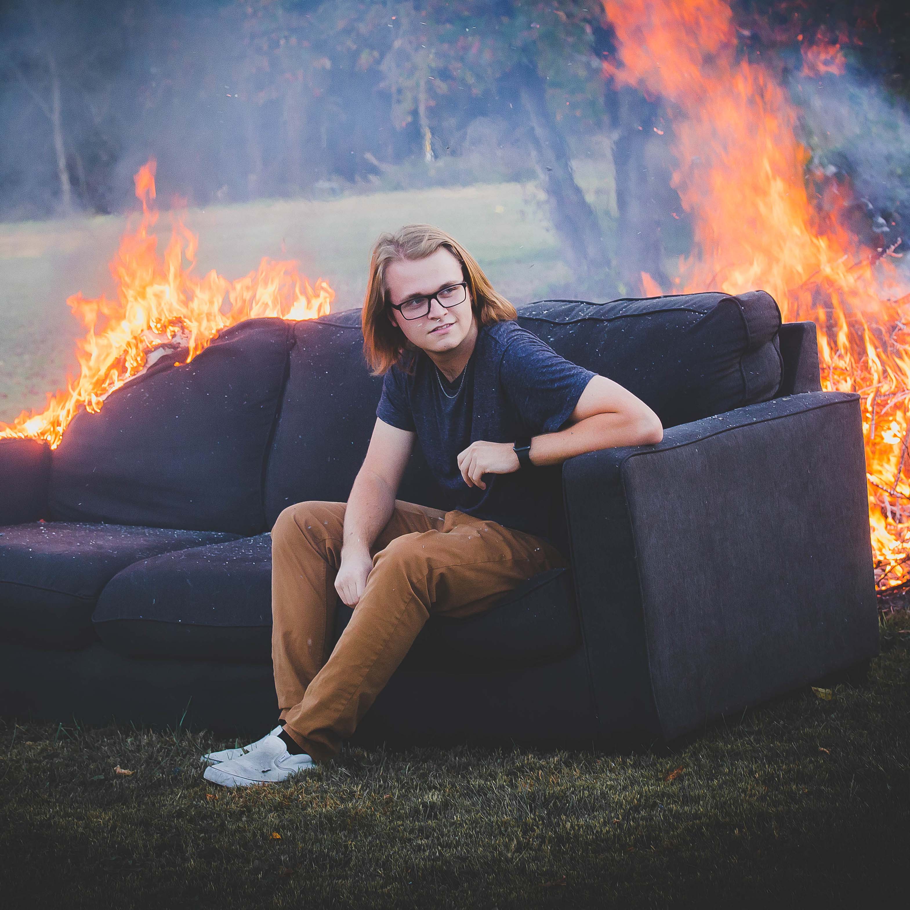 a photo of luke spine sitting on a burning couch